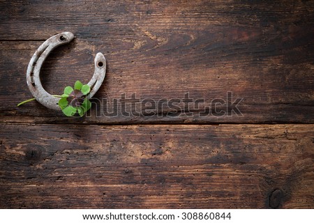 St.Patricks day. Four leaved clover and a horseshoe on wooden board