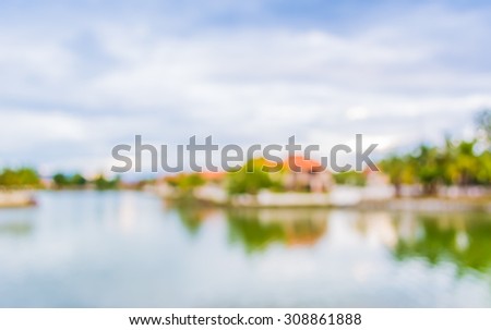 blur image of lake and sunset sky in background .