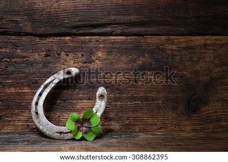 St. Patricks day. Four leaved clover and a horseshoe on wooden board