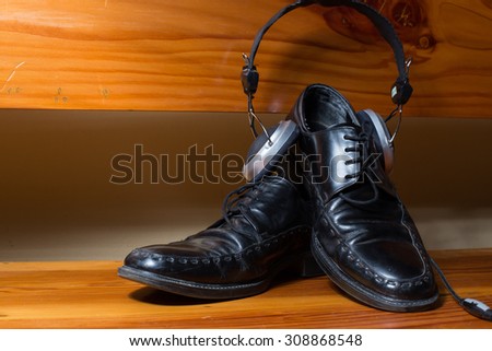 Black boots and earphone with wooden background