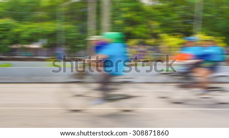 blur (on biker) image of A racing bike rider on the road. take photo with slow speed shutter technique.