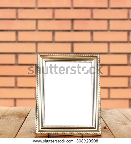 Photo frame standing on table on brick wall background