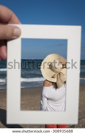 in a white photo frame young woman looking at sea