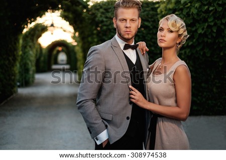 Well-dressed couple in a beautiful alley  Royalty-Free Stock Photo #308974538