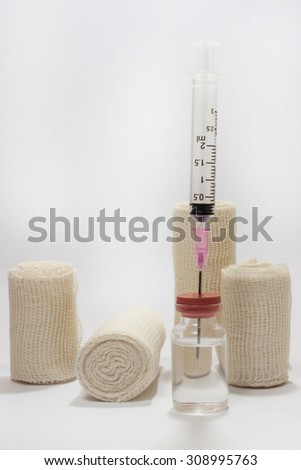 The needle with a syringe and medical bandage on the white background.