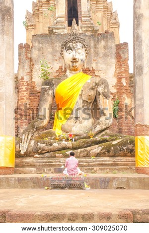 A Stone Sculpture of Great Buddha [Sukhothai Style architecture], At "Wat Mahathat" in Sukhothai Historical Park, Sukhothai Province, Thailand. [Original Warm Collection]