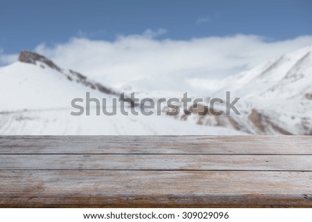 wood table with snow peak and blue sky background