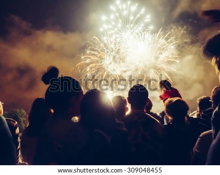 Crowd watching fireworks and celebrating Royalty-Free Stock Photo #309048455