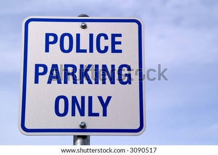 Sign for Police Parking Only on background of blue sky with clouds positioned to left of photo