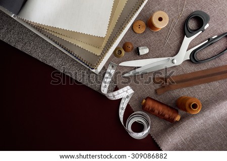 Scissor, buttons, zip, tape measure, thread and thimble on fabrics Royalty-Free Stock Photo #309086882
