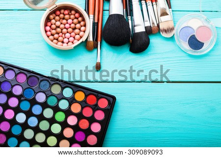 Colorful cosmetics on blue wooden workplace. Top view and picturesque