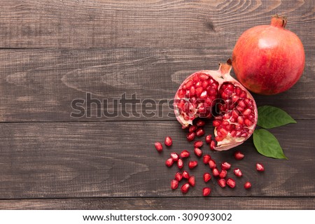 Ripe pomegranate fruit on wooden vintage background. Royalty-Free Stock Photo #309093002