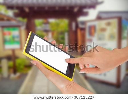 Closeup of hand holding phone in a city park