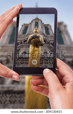 a woman using a smart phone to take a photo of an ancient temple in thailand