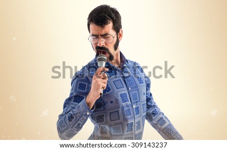Vintage young man singing with microphone  Royalty-Free Stock Photo #309143237