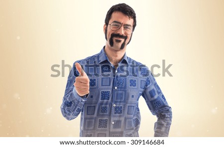 Vintage young man with thumb up over ocher background