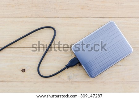 External hard drive for backup on wood background. Royalty-Free Stock Photo #309147287