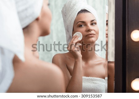 Young beauty woman removing makeup in the bathroom Royalty-Free Stock Photo #309153587