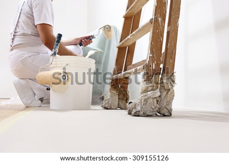 painter man at work with a roller, bucket and ladder, bottom view Royalty-Free Stock Photo #309155126