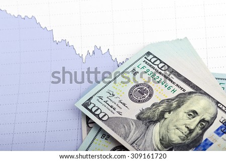 Business concept. Heap of dollar bills on paper background with business chart