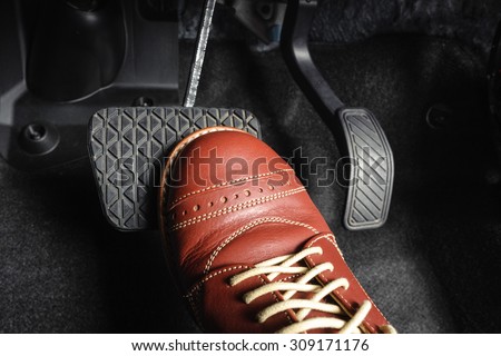 foot pressing the brake pedal of a car Royalty-Free Stock Photo #309171176