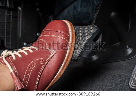 foot pressing the brake pedal of a car Royalty-Free Stock Photo #309189266