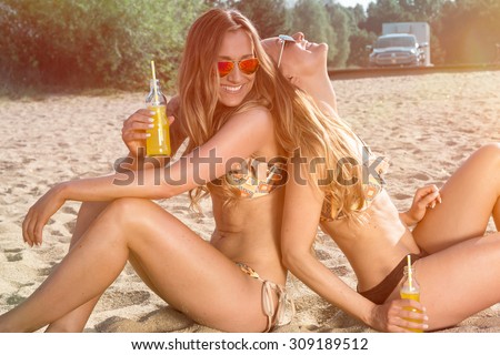 summer holidays and vacation, girls in bikinis with drinks on the beach
