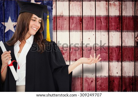 A woman holding her hand out with a degree in her other hand as she smiles against composite image of usa national flag