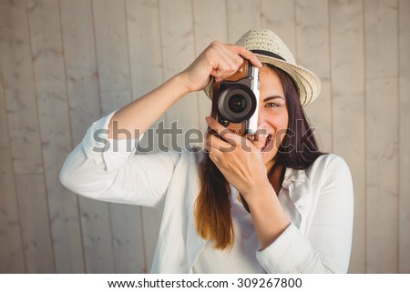 Pretty hipster using her vintage camera on wooden planks background