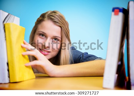 Pretty student in the library against blue background with vignette