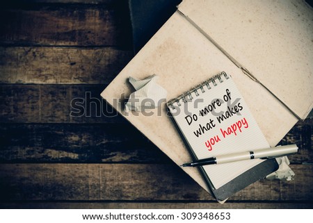 Do more of  what makes you happy on pages sketch book on wood table vertical 