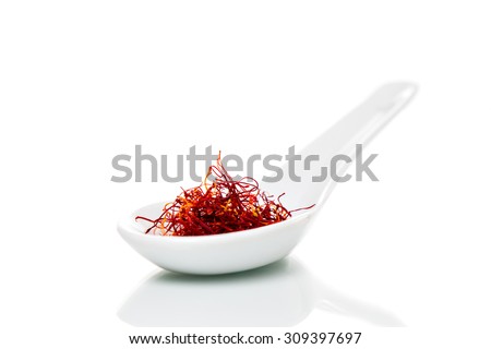 Saffron (Crocus sativus) threads on a white porcelain spoon Royalty-Free Stock Photo #309397697