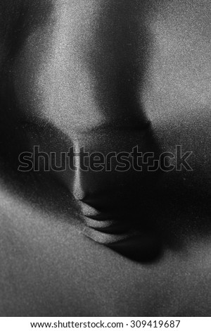 Mysterious closeup portrait background of female human face under beautiful pearl silver supplex stretch fabric black and white copyspace, vertical picture