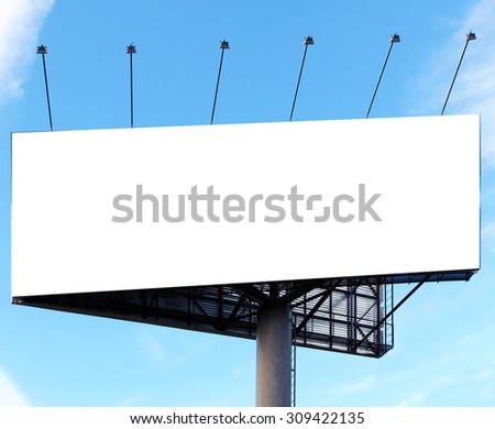 Wide white background of illuminated big blank billboard over cloudy bright blue sky in sunny day. Successful concept of promotion products and items outdoor. Clear space of empty board for your text