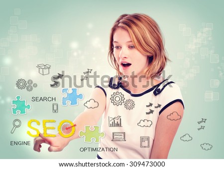 Pretty young woman activating an SEO interface on a virtual screen with scattered SEO icons for optimizing a website