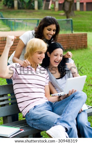 young college students playing computer game outdoors