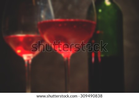 red wine in two goblets and green bottle. romantic blur effect. instagram image filter retro style