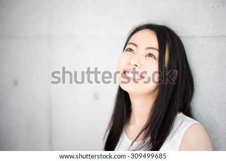 beautiful young woman against concrete wall