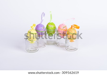 Decorated eggs in empty mason jar over white background