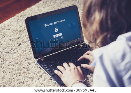 "Secure payment" on laptop screen. Woman making a secure payment through the internet with a laptop computer