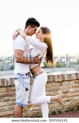 Young romantic couple hugging and about to kiss in beautiful sunset