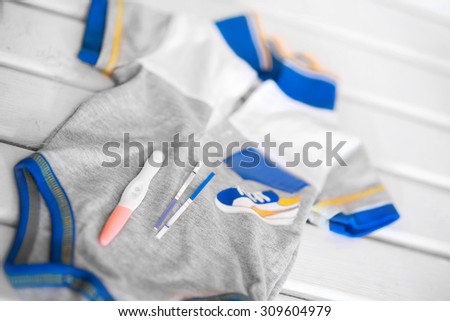 A Positive pregnancy test on a rompers