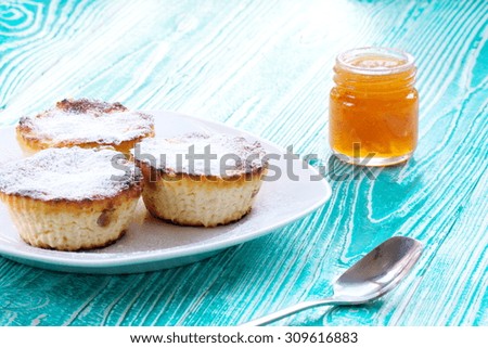 cheesecakes and jar of apricot jam on turquoise colored wooden table