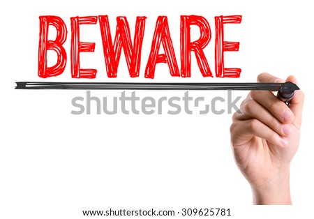Hand with marker writing the word Beware Royalty-Free Stock Photo #309625781
