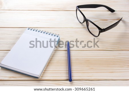 Back to school. Blank notepad, notebook with pen and glasses on wooden background. Copy Space. Education background