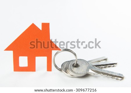 Silver key with orange house figure. Real Estate Concept.