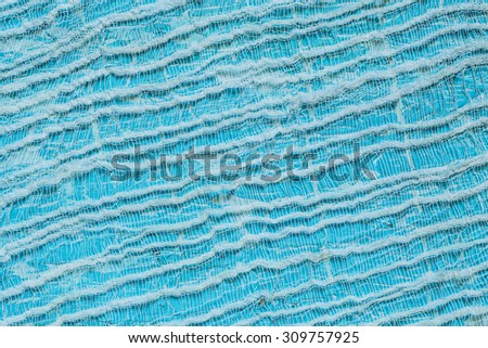 Light blue painted background with old tenuous gauze on the surface