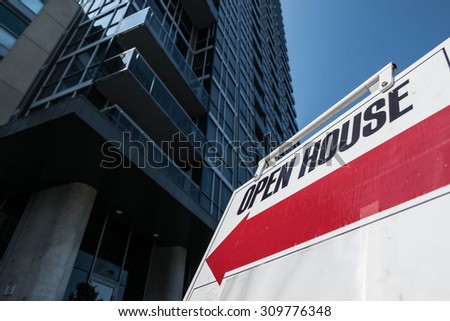 Open House Condominium High-rise. An open house sign in front of a highrise urban condominium.