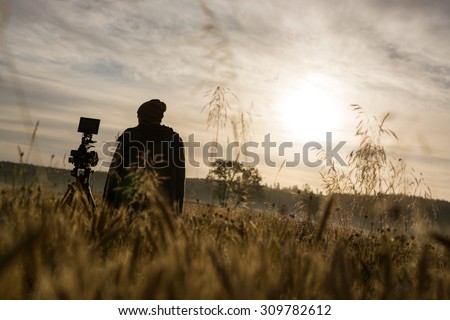 Photographer or filmmaker early in the morning honing his craft. Going that extra mile for a good shot.  Royalty-Free Stock Photo #309782612