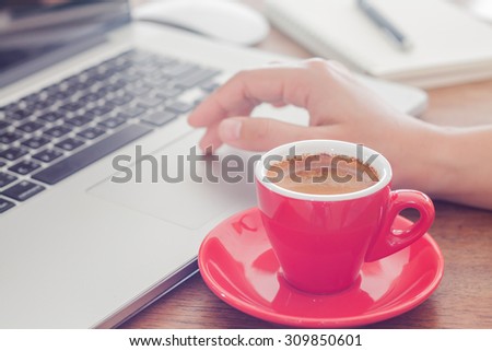 Red coffee cup with notepad and laptop, stock photo